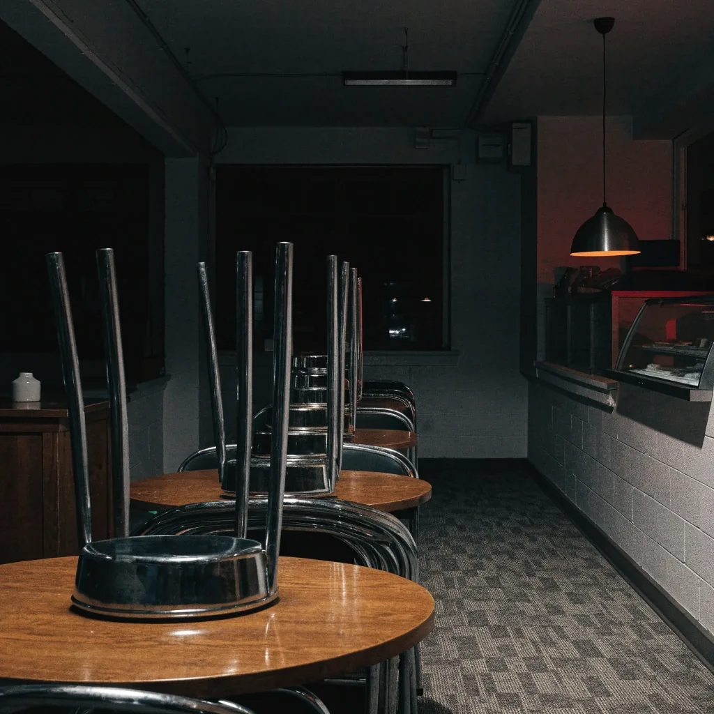 Dining room after close with chairs stacked and one lamp lit