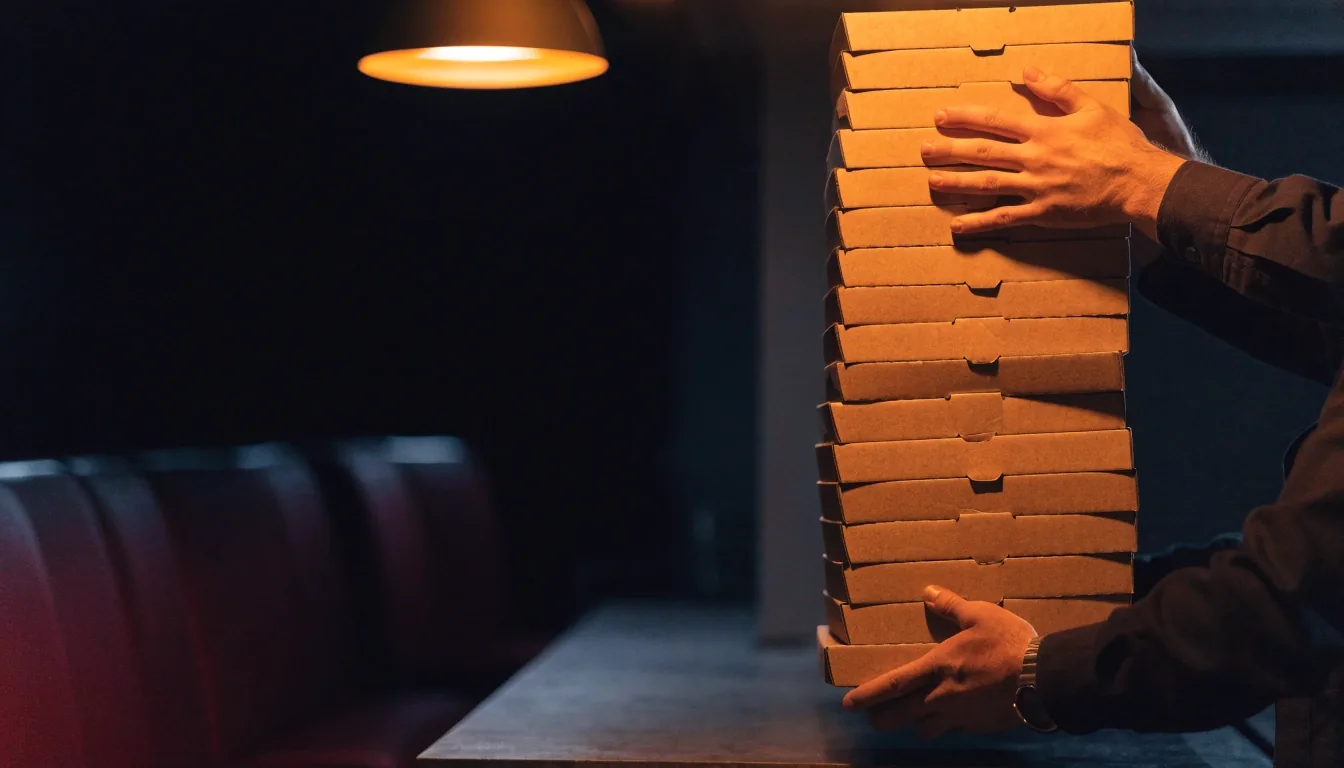 Office lunch with opened pizza boxes on a meeting table